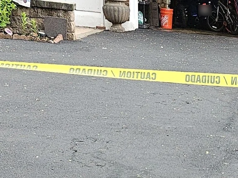 Freshly sealcoated driveway taped off while it cures